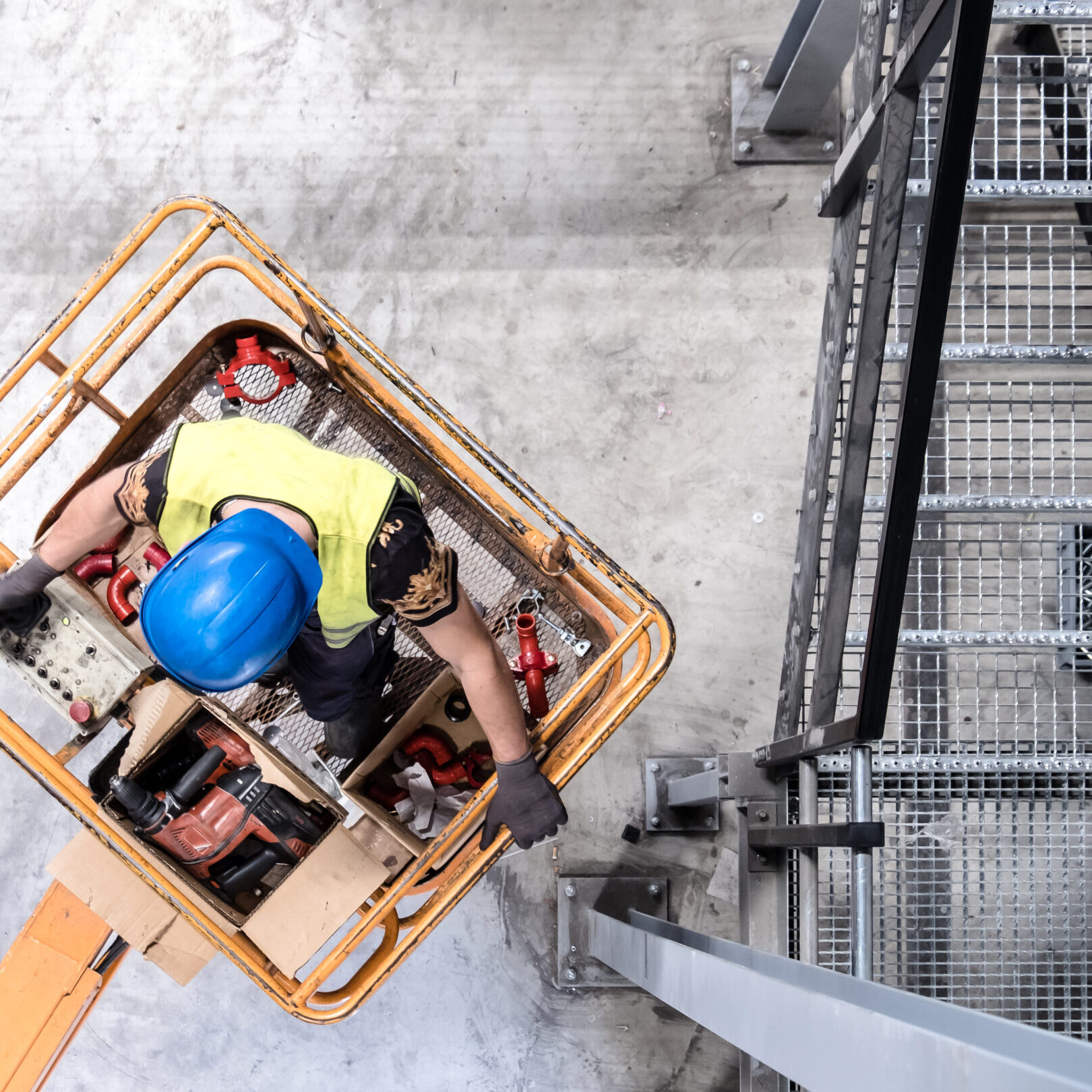 Aerial of a worker with blue hardhat on a cherry picker
